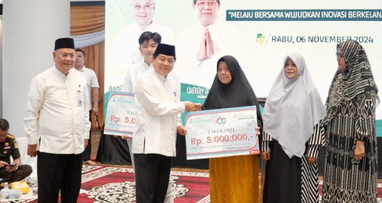 Direktur Utama Bank Sumsel Babel, Achmad Syamsudin, menyerahkan bantuan kepada masyarakat, dalam rangka peringatan Hari Ulang Tahun ke 67. (foto : WartaNegeriku.id/Humas Pemprov Sumsel)