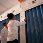 Petugas dari Pemerintah Kabupaten Ogan Komering Ilir sedang melakukan pemasangan stiker pada kios pedagang yang menunggak retribusi di Pasar Rakyat Kayuagung, pada hari Rabu, tanggal 3 Desember 2025. (foto : Humas Pemkab OKI)