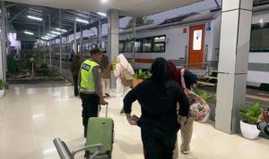 Personel Polres Ogan Komering Ulu (OKU) membantu dua pemudik yang tertinggal kereta api di Stasiun Kereta Api Baturaja, Sumatra Selatan. (WARTANEGERIKU.ID)