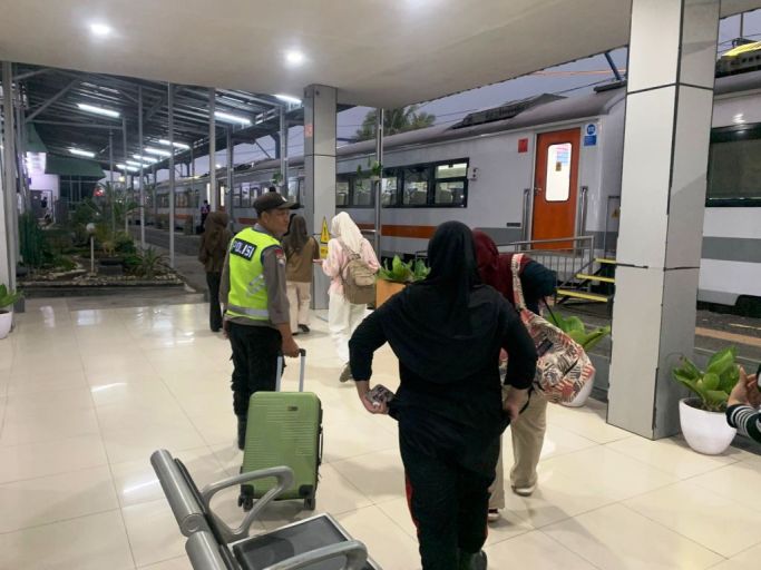 Personel Polres Ogan Komering Ulu (OKU) membantu dua pemudik yang tertinggal kereta api di Stasiun Kereta Api Baturaja, Sumatra Selatan. (WARTANEGERIKU.ID)