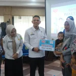 Staf Ahli Bupati Muba Akhmad Toyibir bersama perwakilan Indomaret menyerahkan paket bantuan nutrisi kepada perwakilan ibu dan balita di Auditorium Pemkab Muba